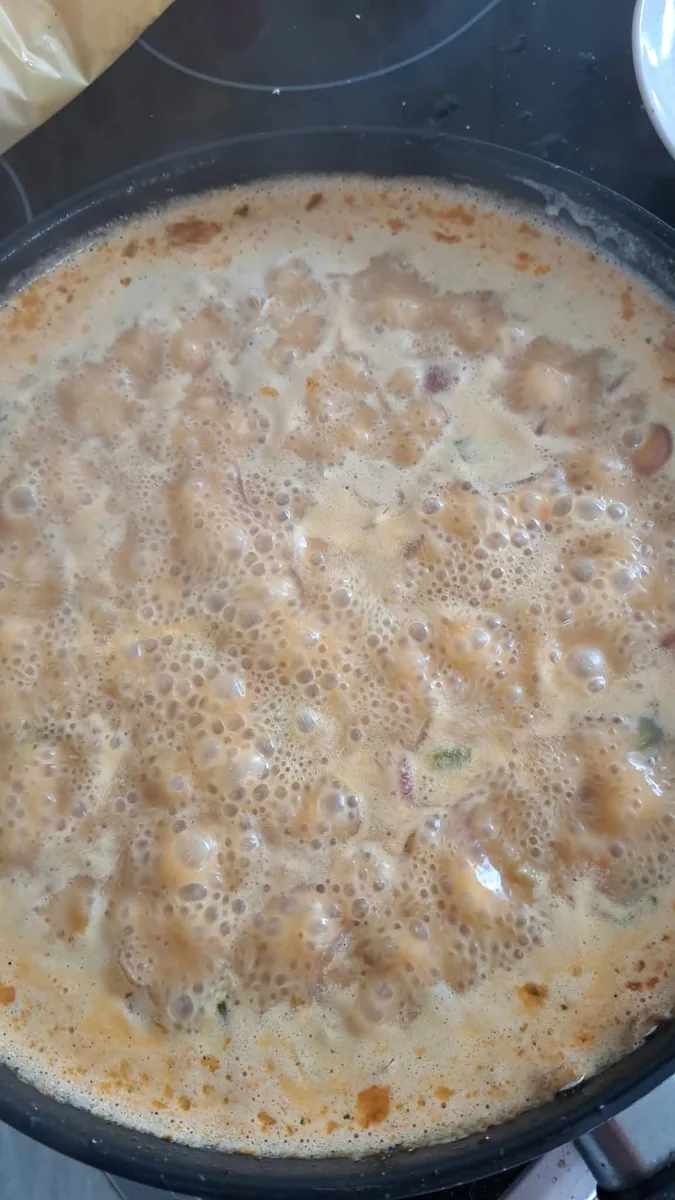 Cremige Soße beim kräftigen Köcheln in der Pfanne